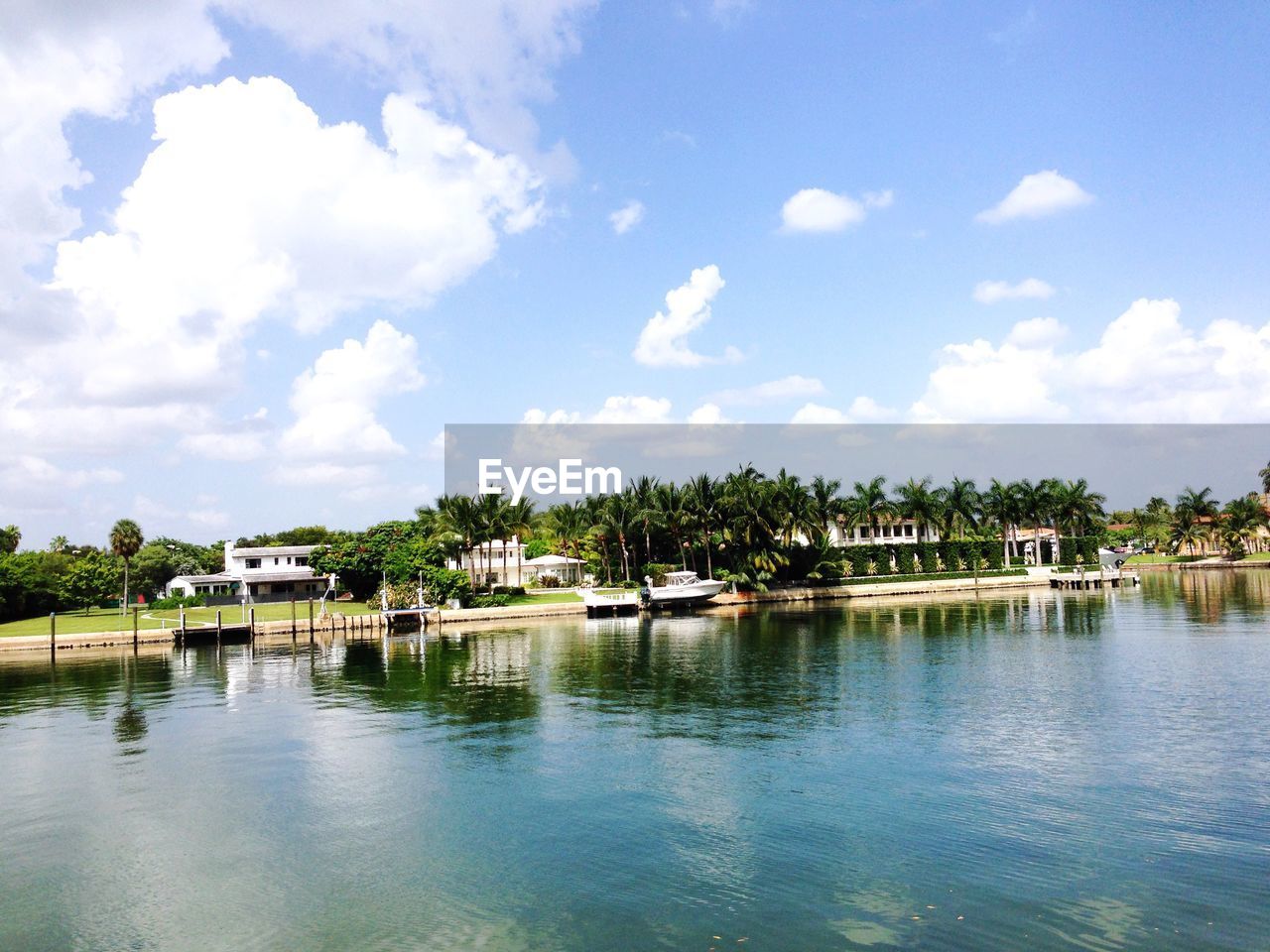 Houses by river against sky