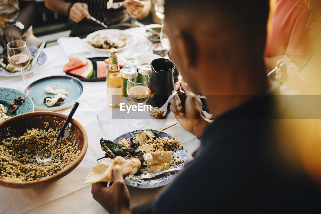 High angle view of man eating dinner at dining table in party