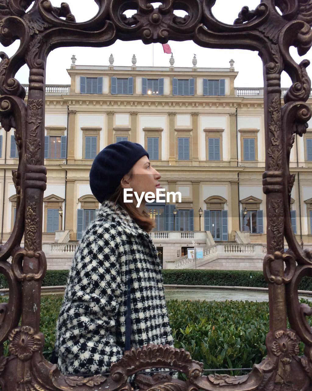 Woman seen through frame standing by buildings