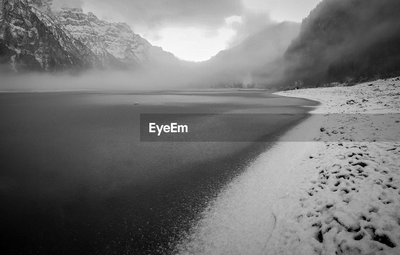 Scenic view of frozen lake against snow covered mountains