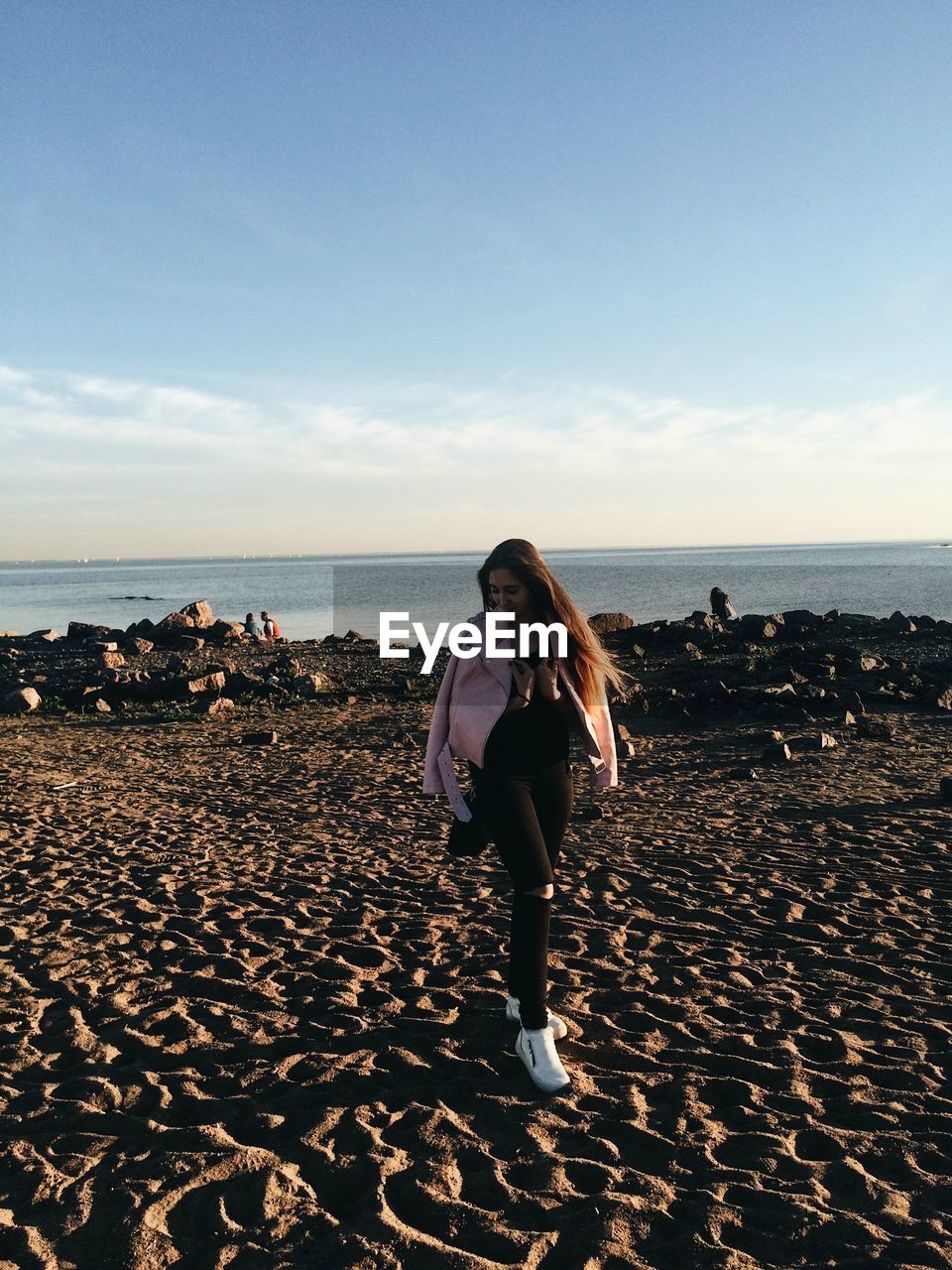 Full length of young woman walking at beach