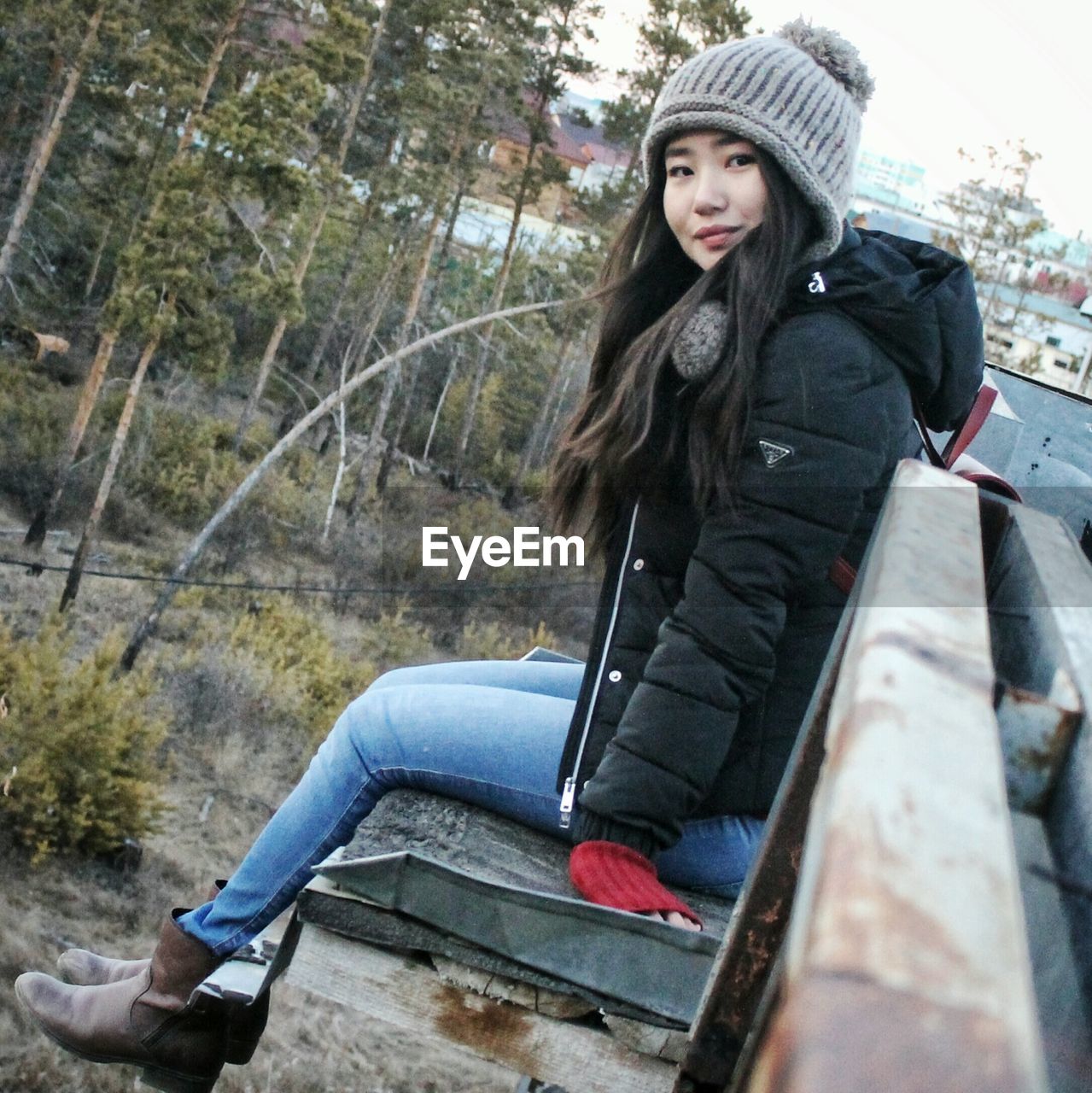 PORTRAIT OF YOUNG WOMAN SITTING IN WINTER