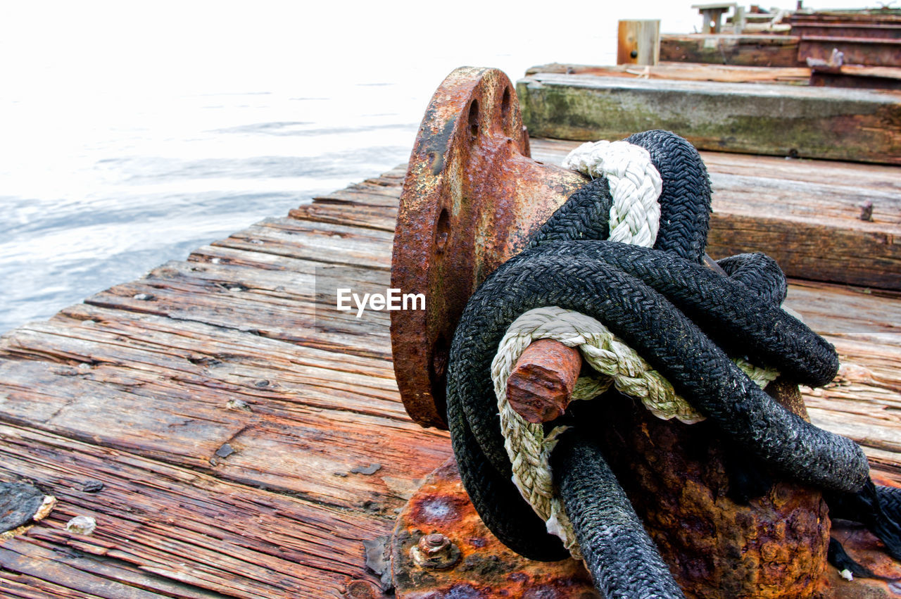 CLOSE-UP OF ROPE ON RUSTY PIER