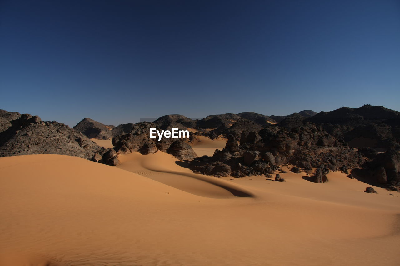 Scenic view of desert against clear sky acacus mountains, libya