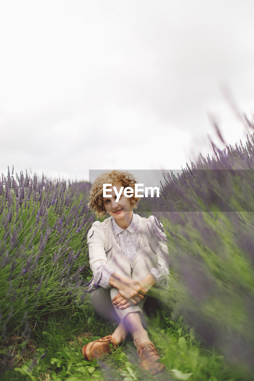 Portrait of woman sitting in grass