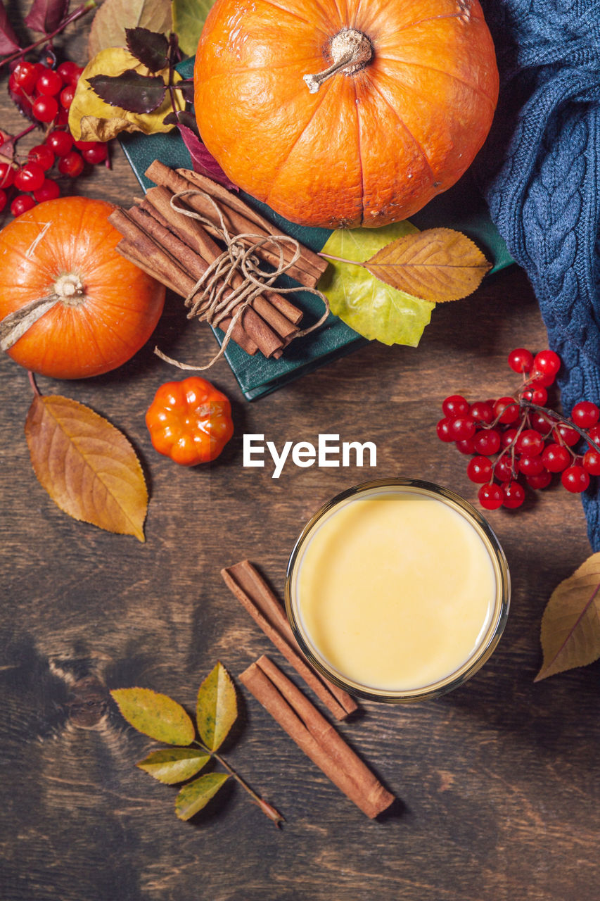 Autumn or winter vegan drink. healthy pumpkin smoothie in glasses on a wooden rustic table. 