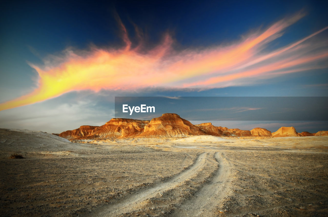 Scenic view of rock formations at desert against sky during sunset