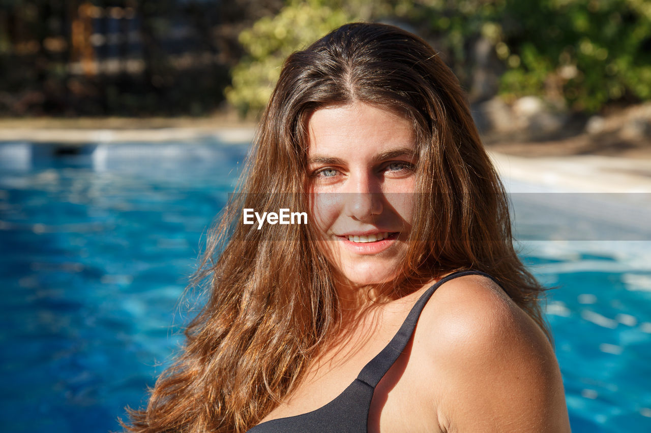 Portrait of smiling young woman in swimming pool