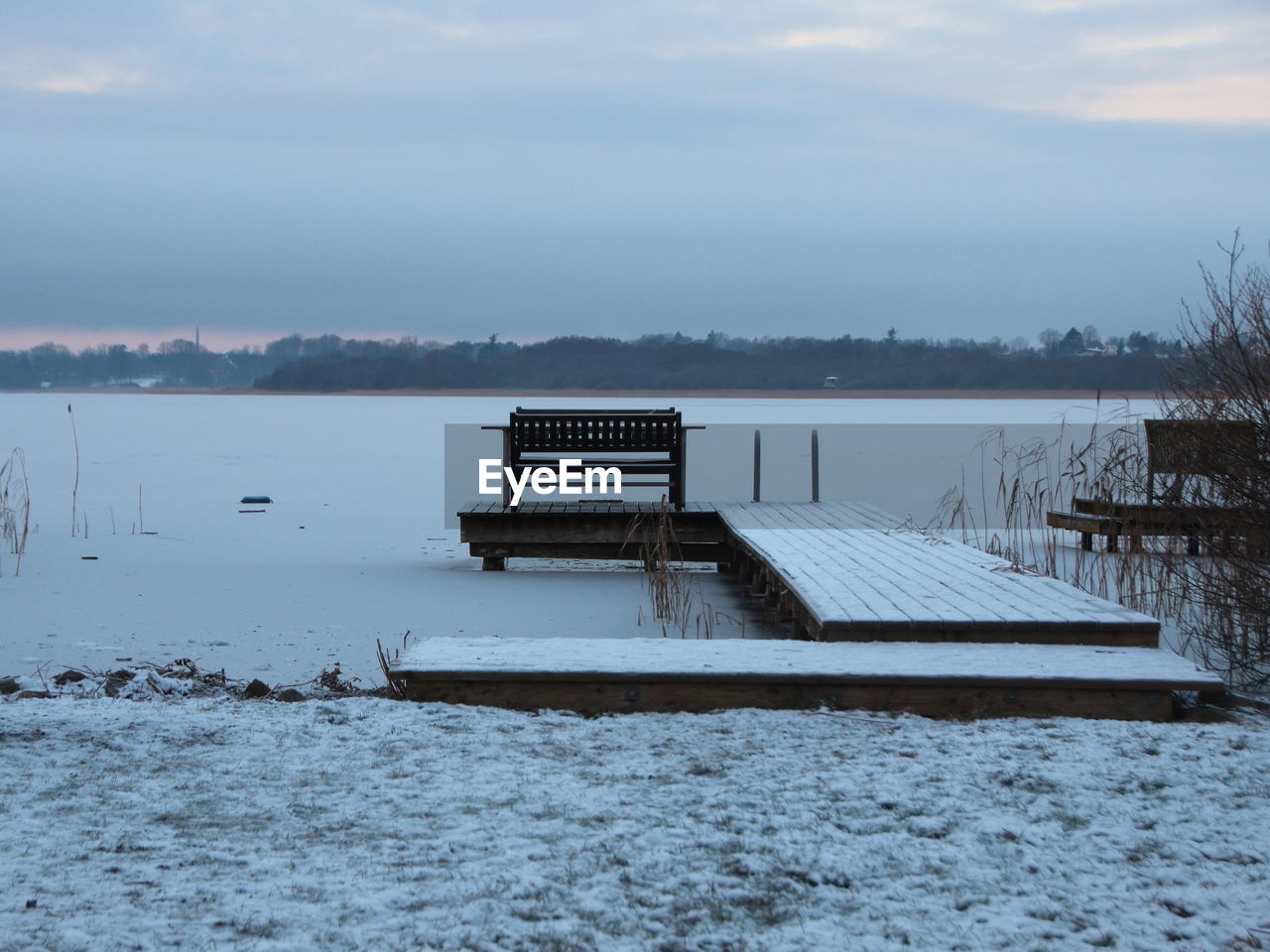 PIER OVER FROZEN LAKE AGAINST SKY