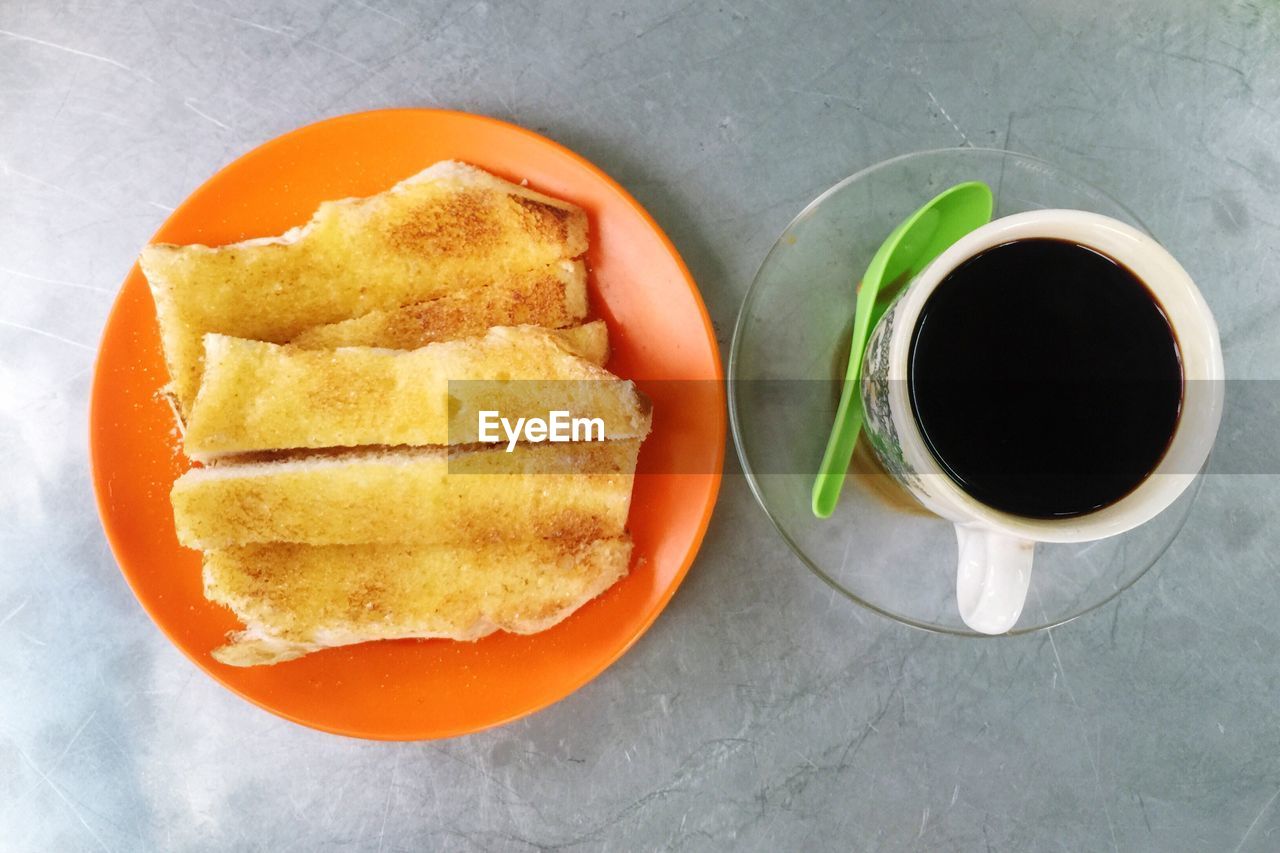 Directly above shot of toasted bread and black coffee for breakfast