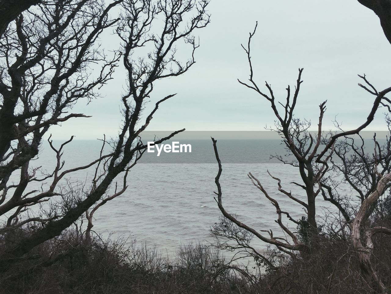 Scenic view of calm sea against cloudy sky