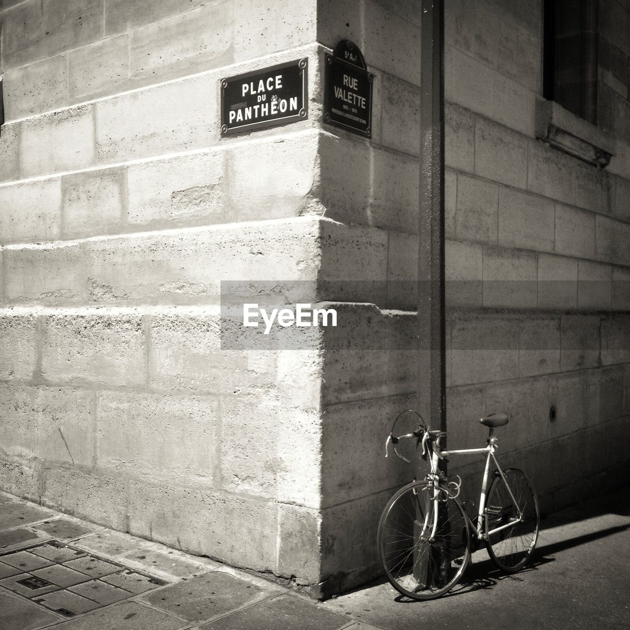 Side view of bicycle parked against wall