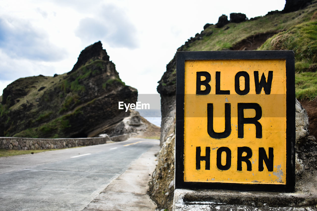 Close-up of road sign against mountain