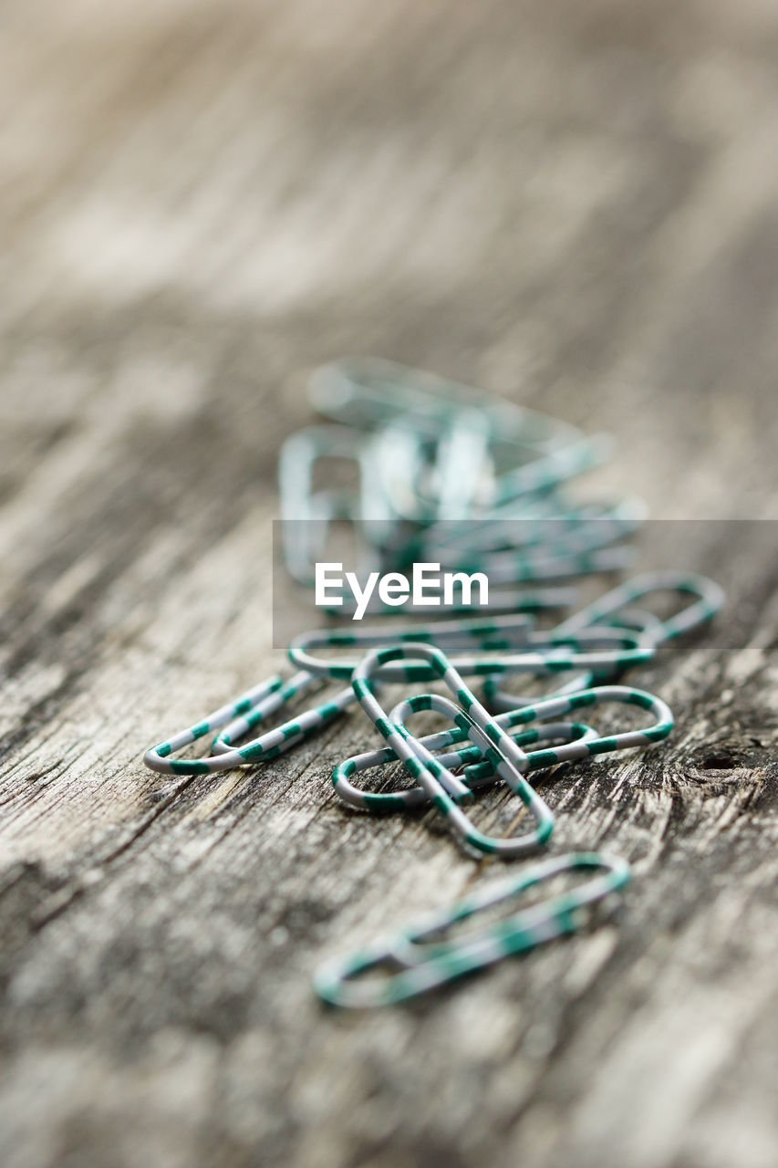 Close-up of paper clips on wooden table