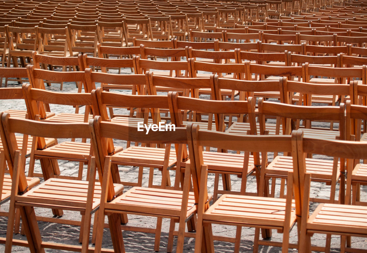 Full frame shot of empty wooden chairs outdoors