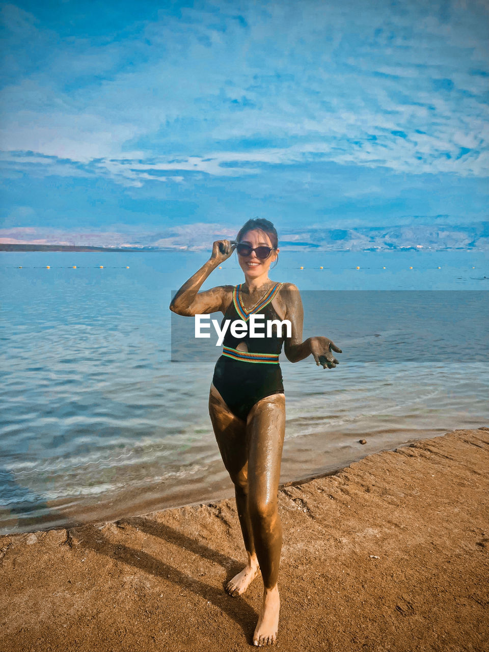 full length of young woman standing at beach