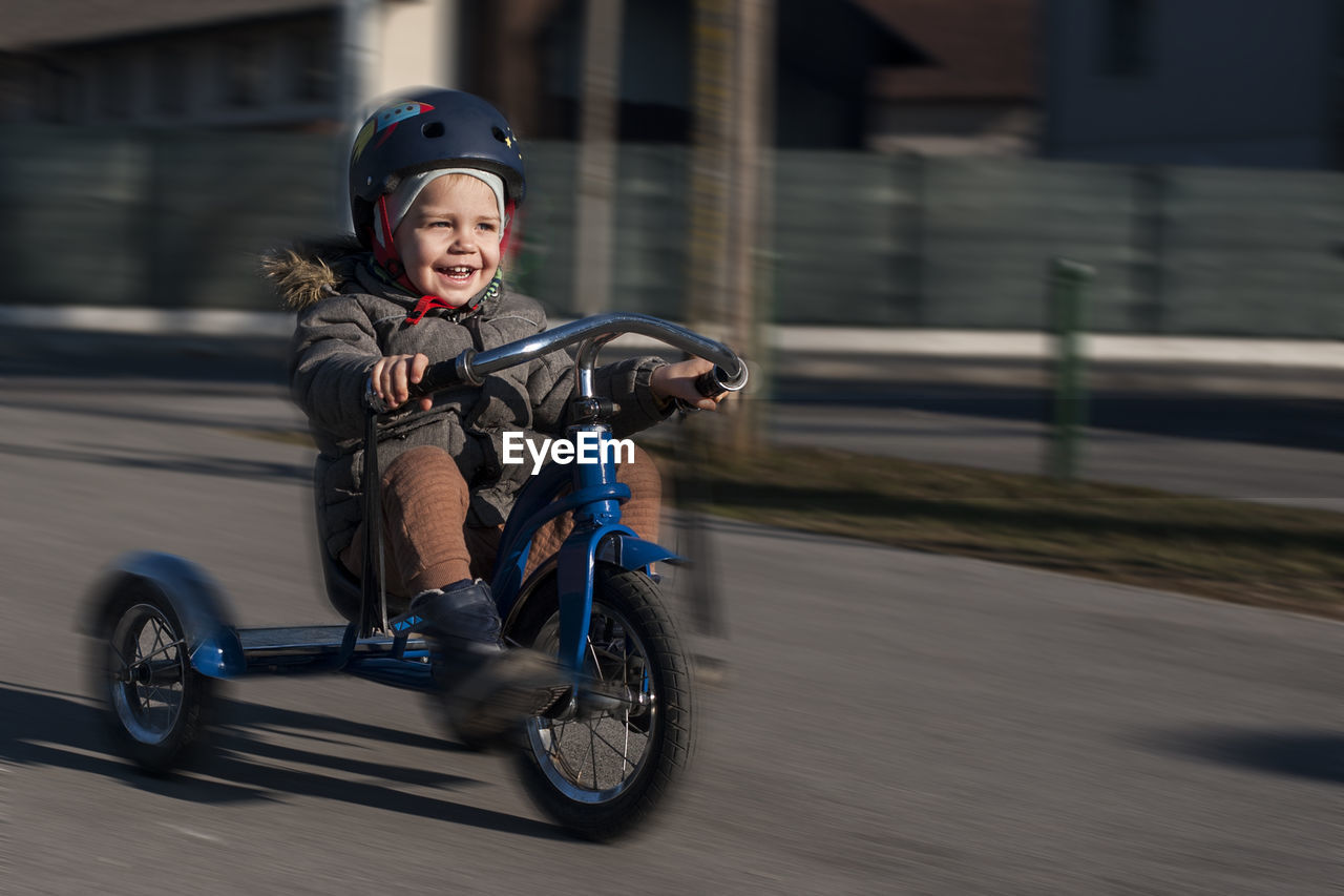 Portrait of boy riding  bycycle on road