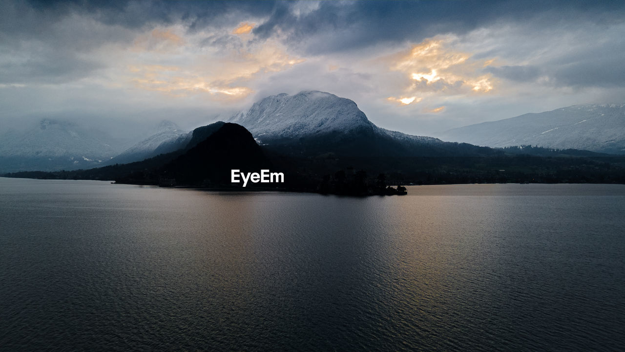 SCENIC VIEW OF SEA BY MOUNTAINS AGAINST SKY