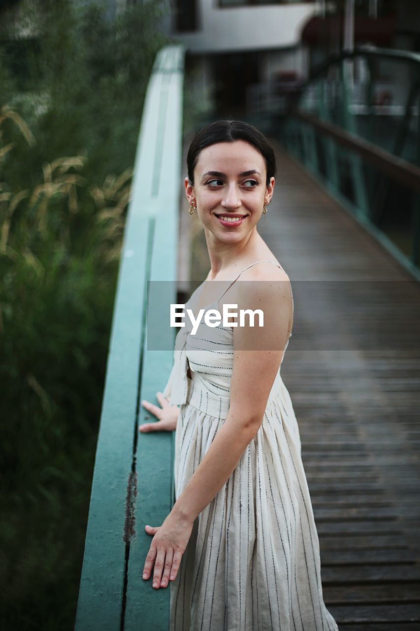 Portrait of a beautiful young woman on a pier