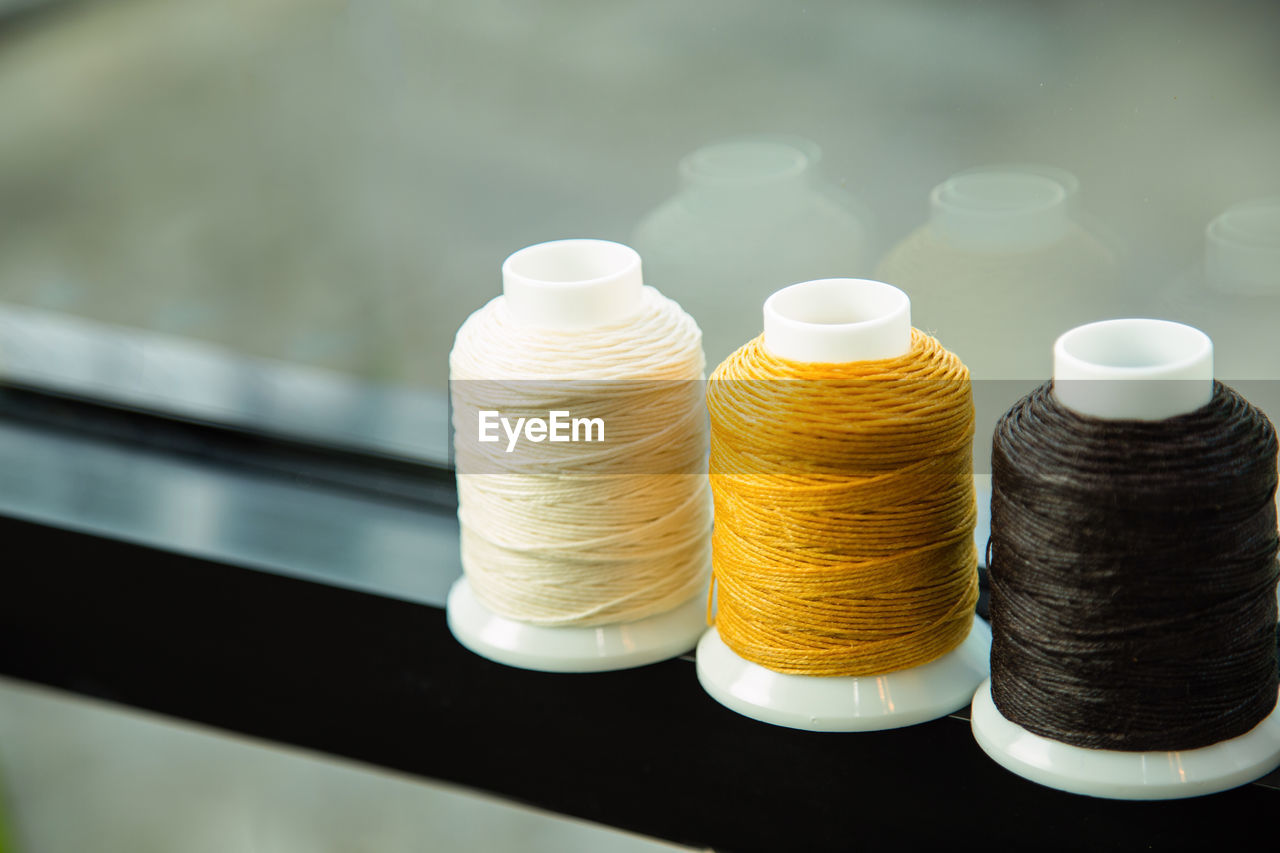 A group of multicolor sewing thread on a window frame and blank for copy space.