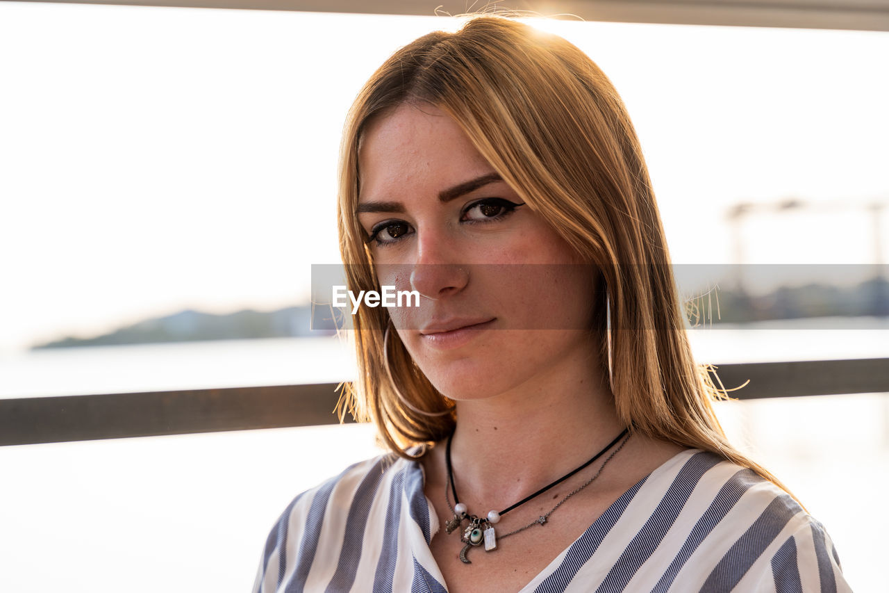 Portrait of a young beautiful woman sitting on a boat sailing during summer vacation on a river