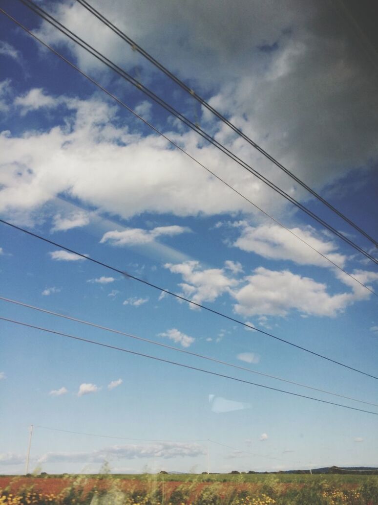 Countryside landscape with cables against sky