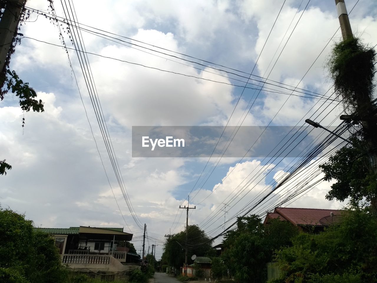 LOW ANGLE VIEW OF POWER CABLES AGAINST SKY