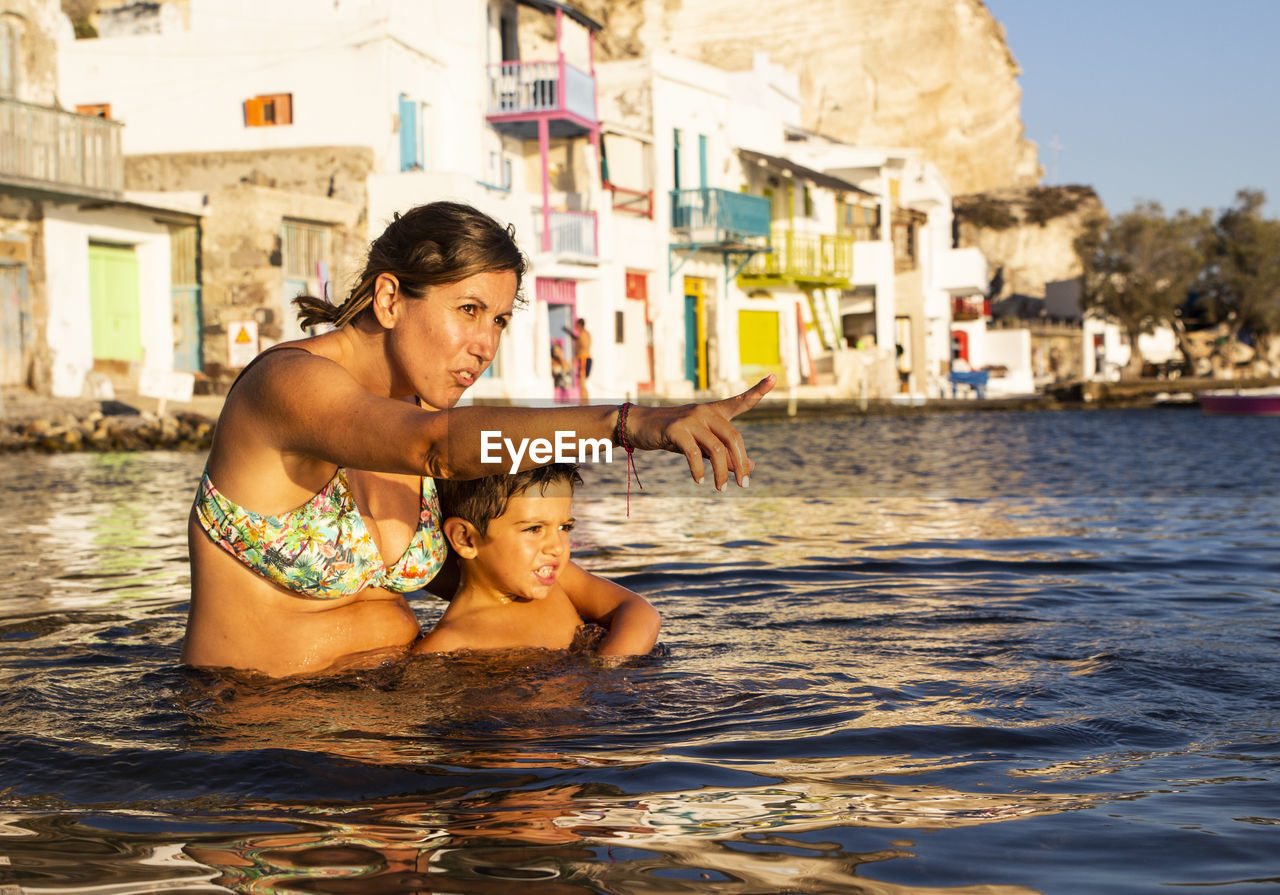 Woman with son pointing in sea