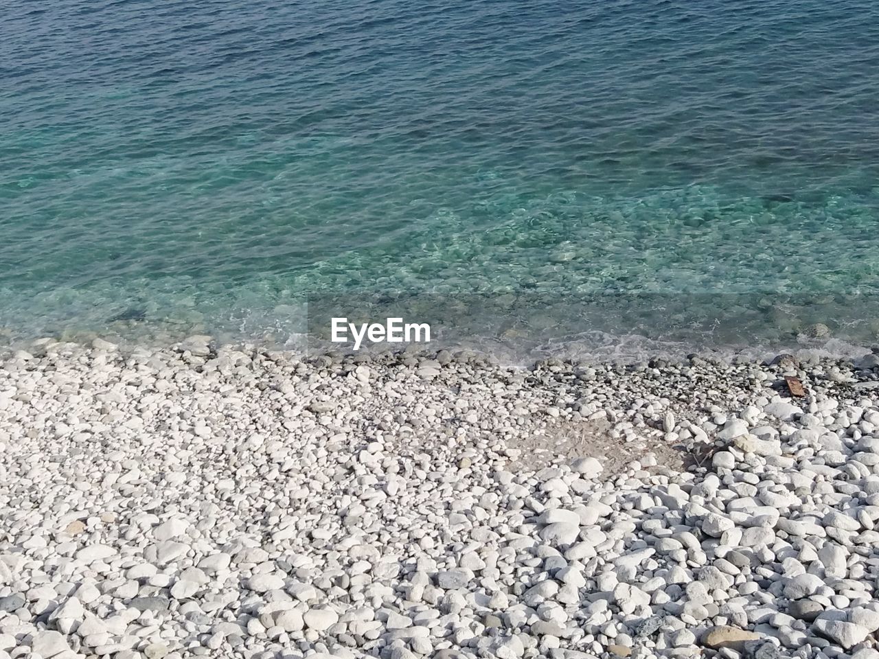 HIGH ANGLE VIEW OF STONES ON BEACH