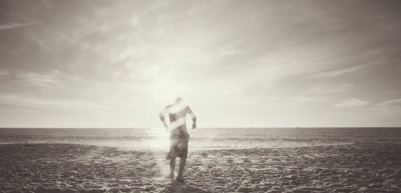 FULL LENGTH OF MAN ON BEACH AGAINST SKY