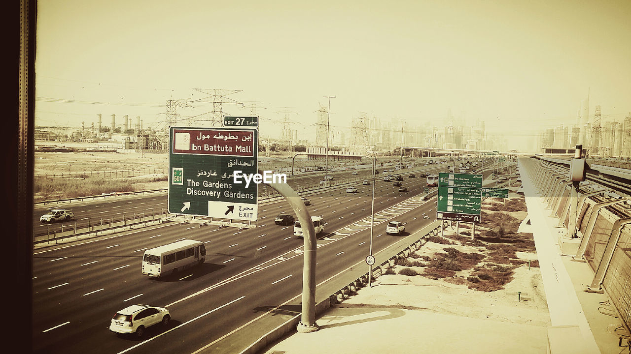 High angle view of road sign by vehicles on street