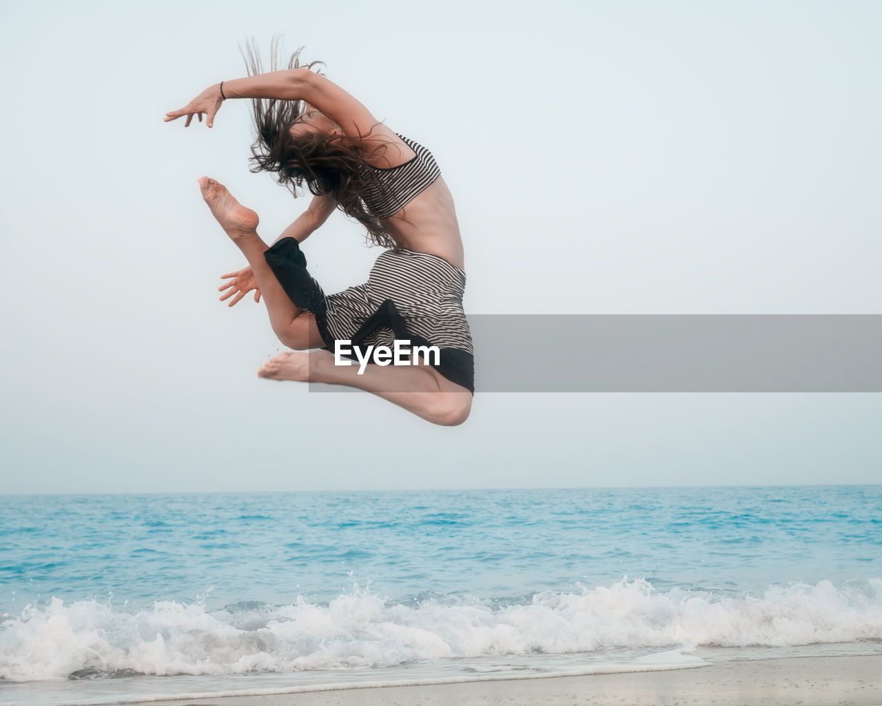 Young woman above sea against clear sky