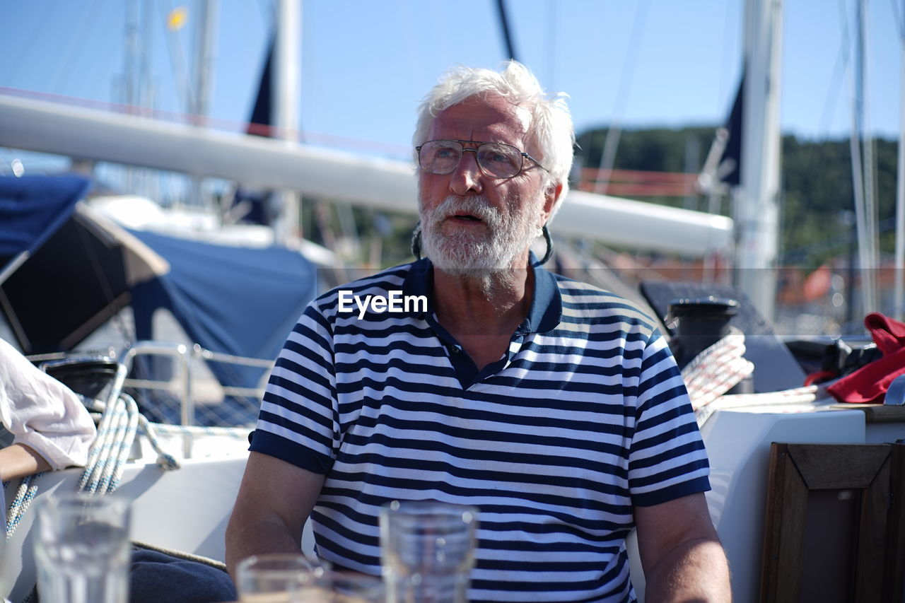 Senior man looking away while sitting in boat