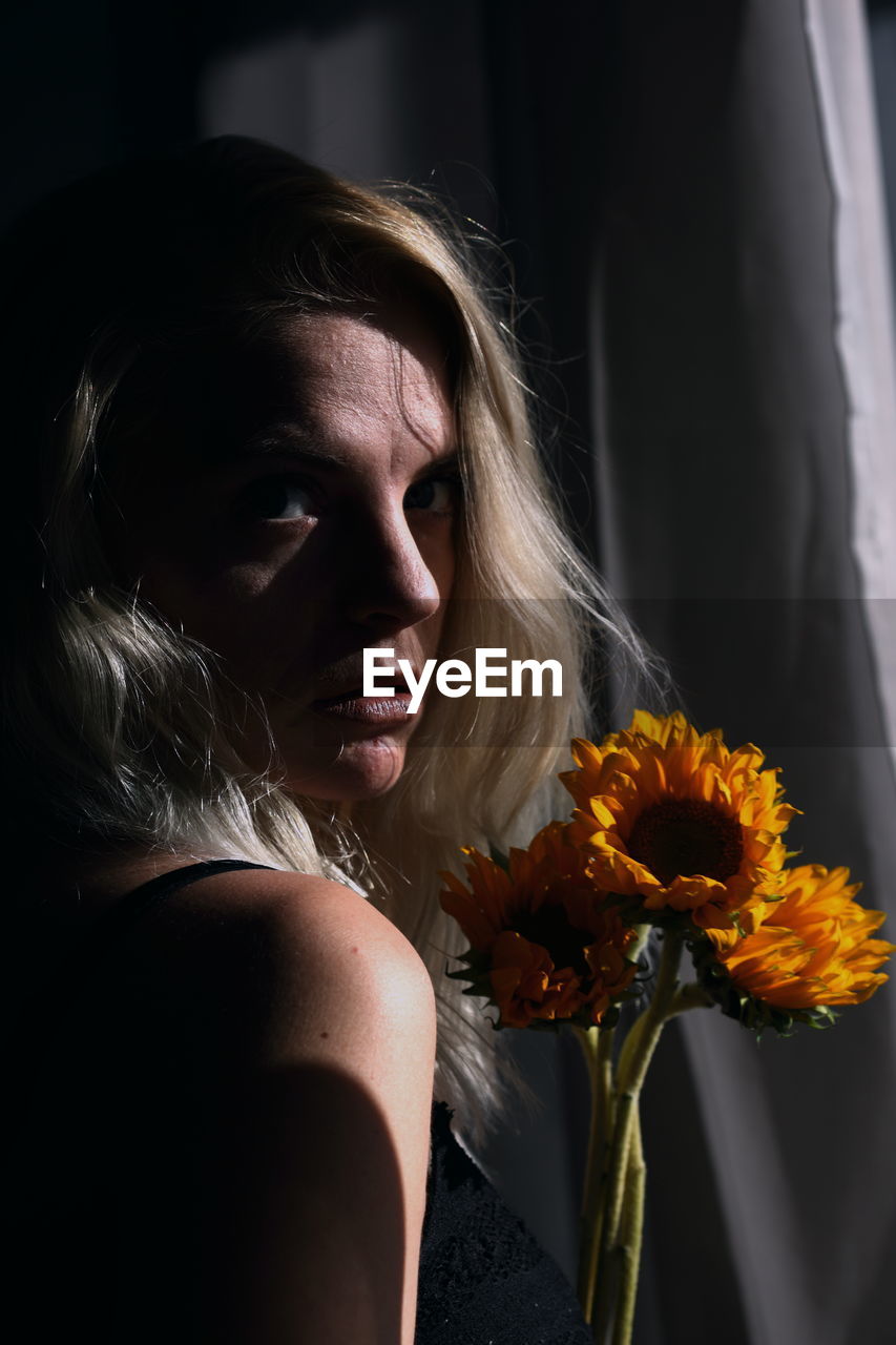 Close-up portrait of young woman with bouquet