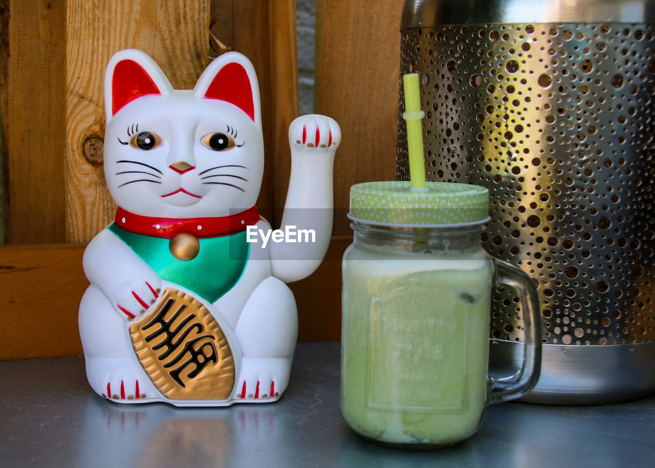 Close-up of figurine and matcha on table