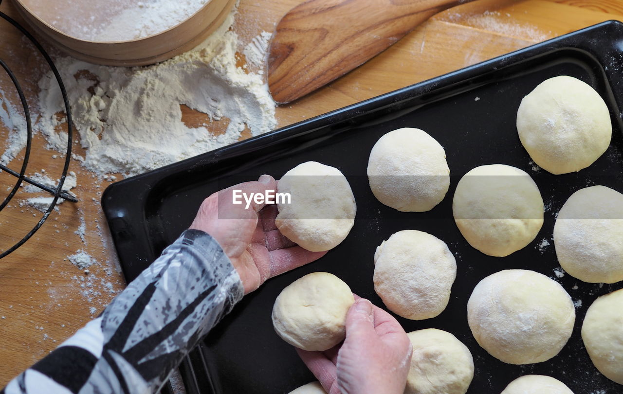 The process of cutting the dough into pieces for baking homemade buns.the woman's hands .