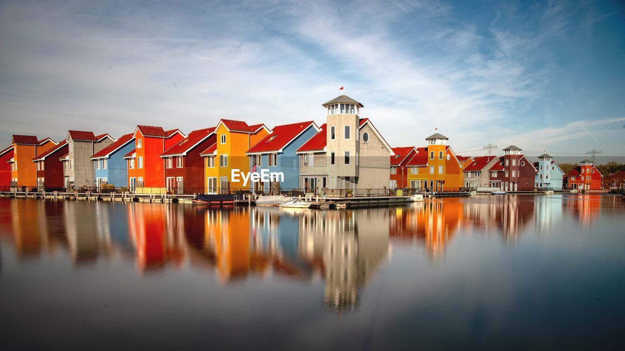 Reflection of buildings on water against sky