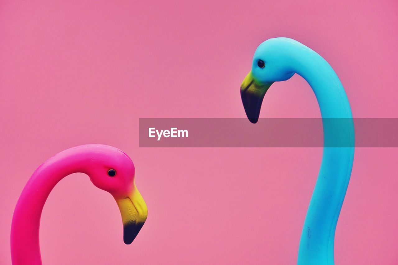 Close-up of artificial flamingoes against colored background