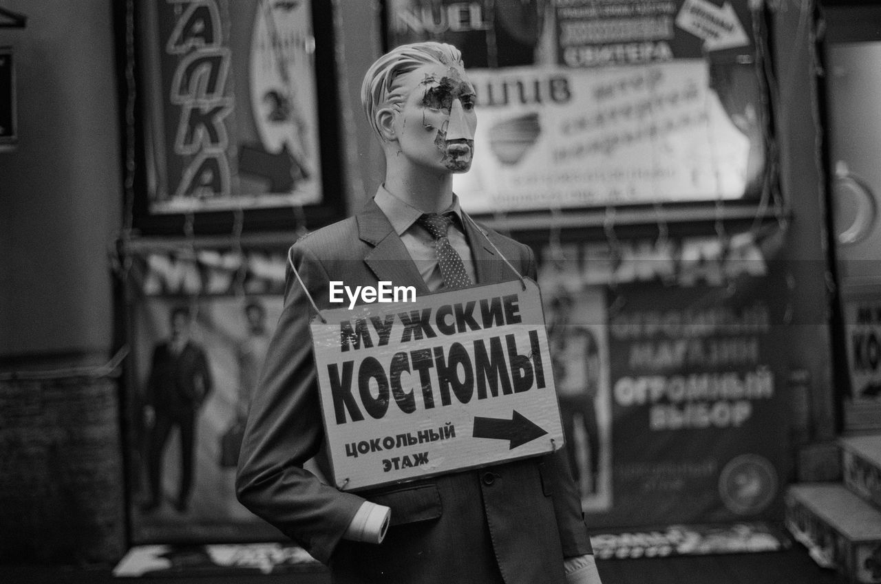 Mannequin with sign board at store