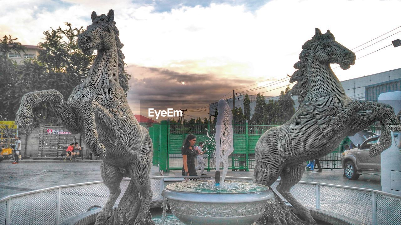 STATUE OF FOUNTAIN AGAINST SKY IN CITY