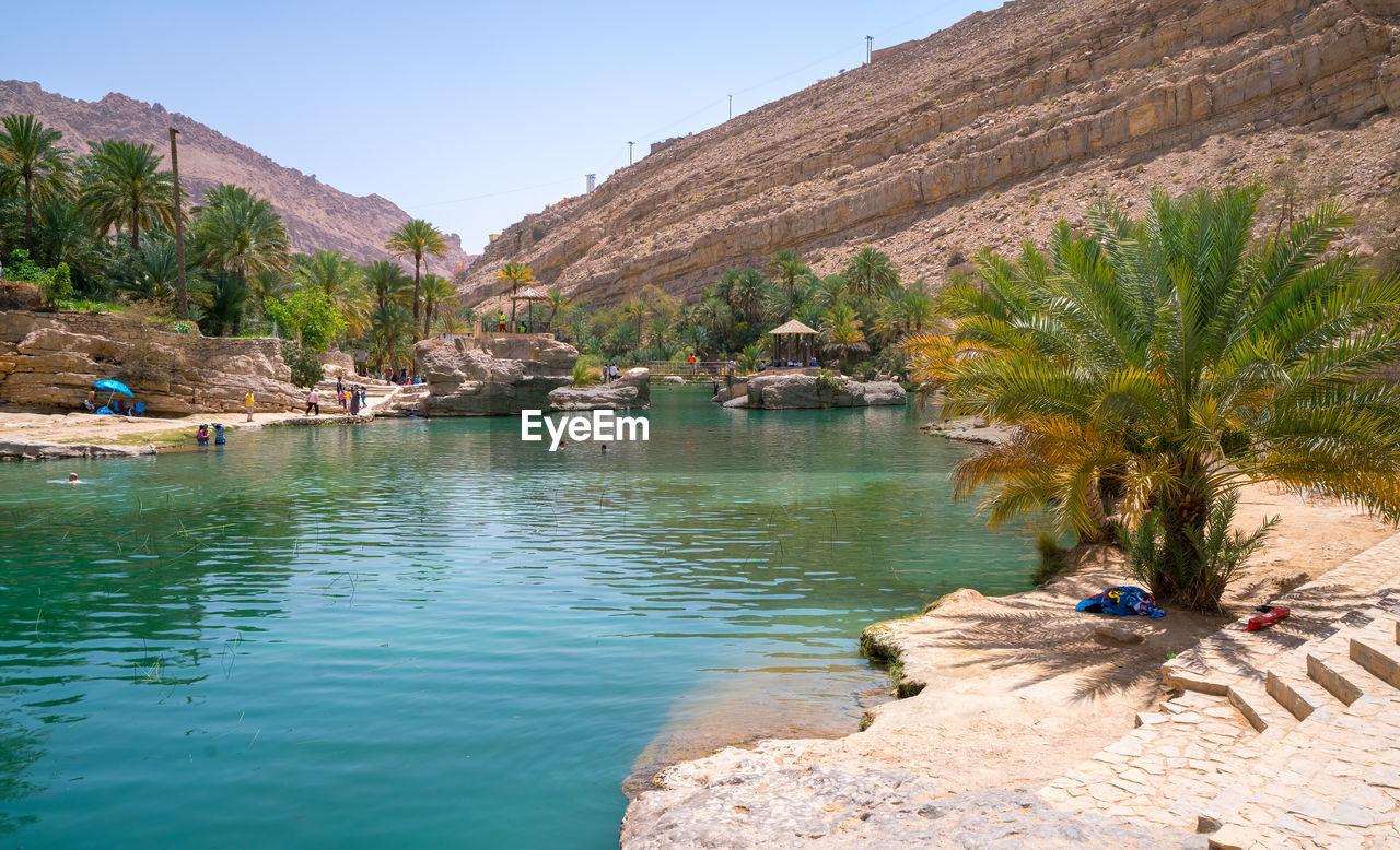 scenic view of lake by mountain against sky