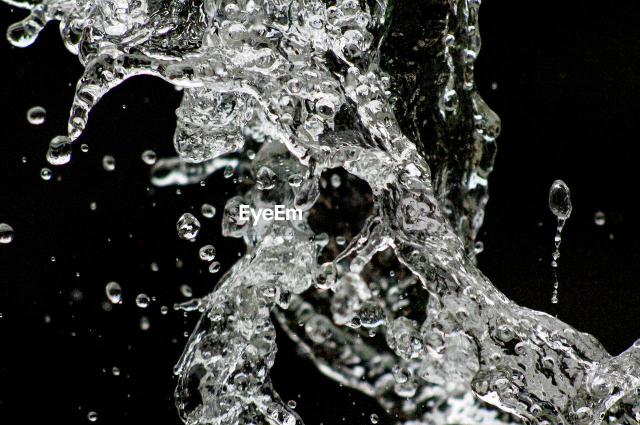 CLOSE-UP OF WATER SPLASHING AGAINST WATERFALL