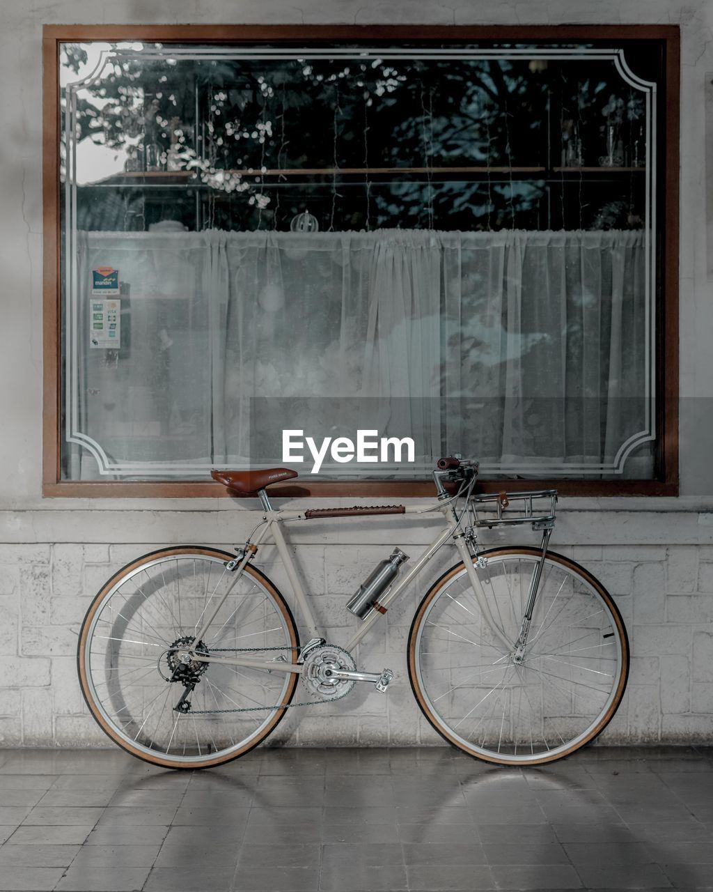 BICYCLE PARKED ON FOOTPATH BY WINDOW