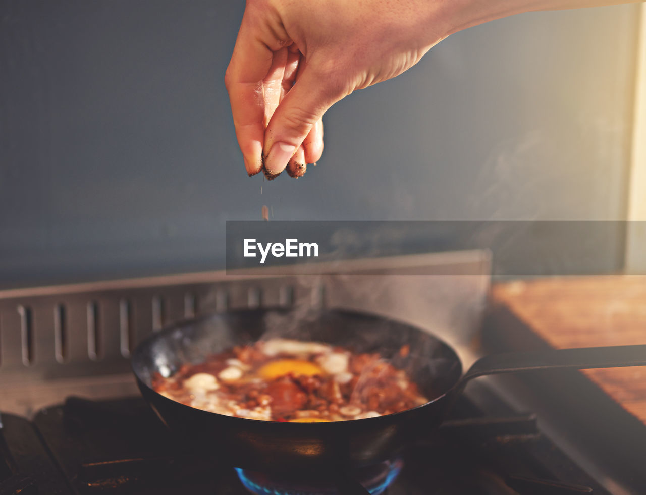 cropped hand preparing food in kitchen