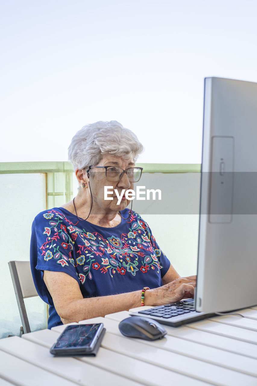 Senior woman using computer on the terrace