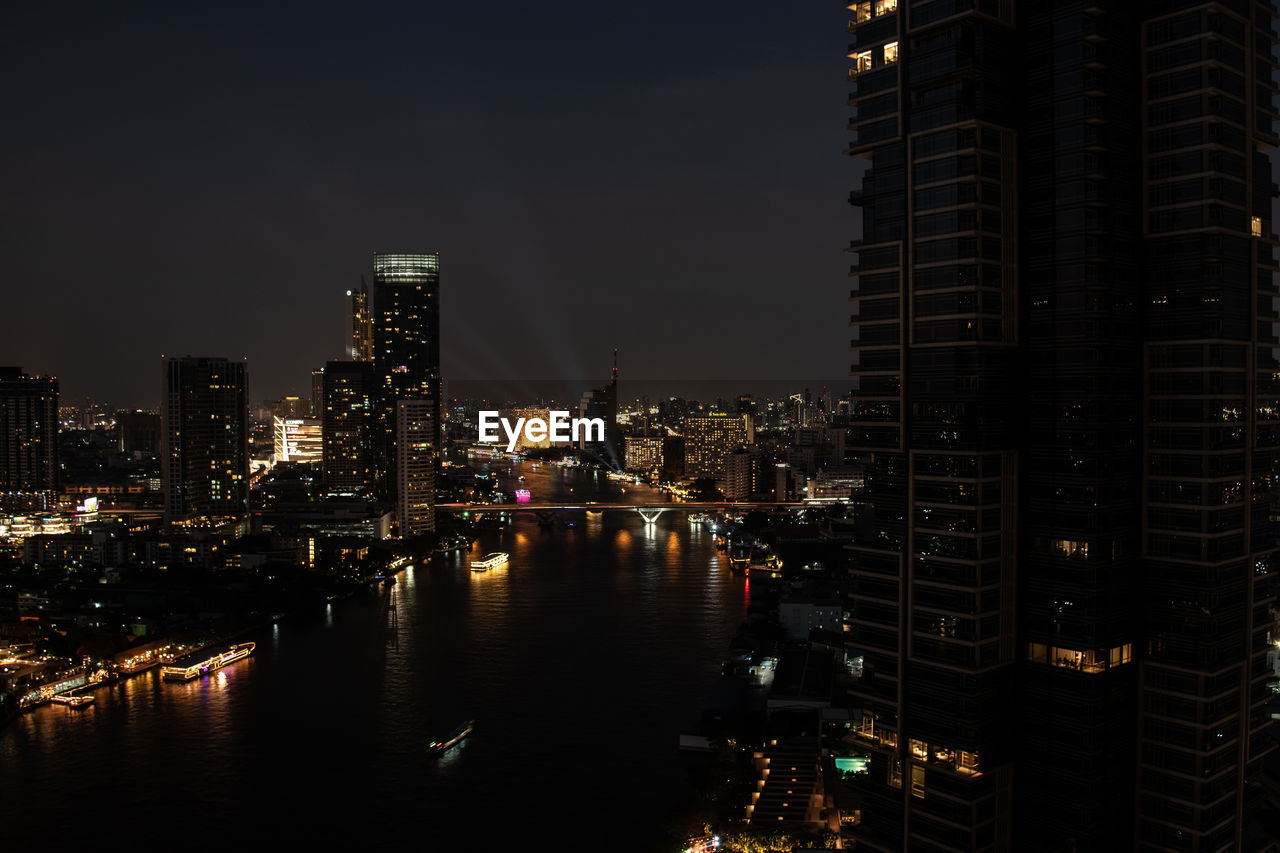 Top view cityscape of bangkok at night with lighting cruises on chao phraya river view