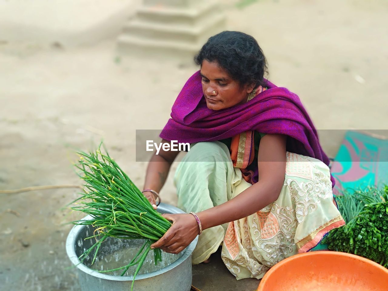 women, one person, adult, female, child, lifestyles, holding, sitting, food and drink, nature, food, vegetable, emotion, smiling, childhood, person, plant, outdoors, happiness, healthy eating, casual clothing, clothing, wellbeing, day