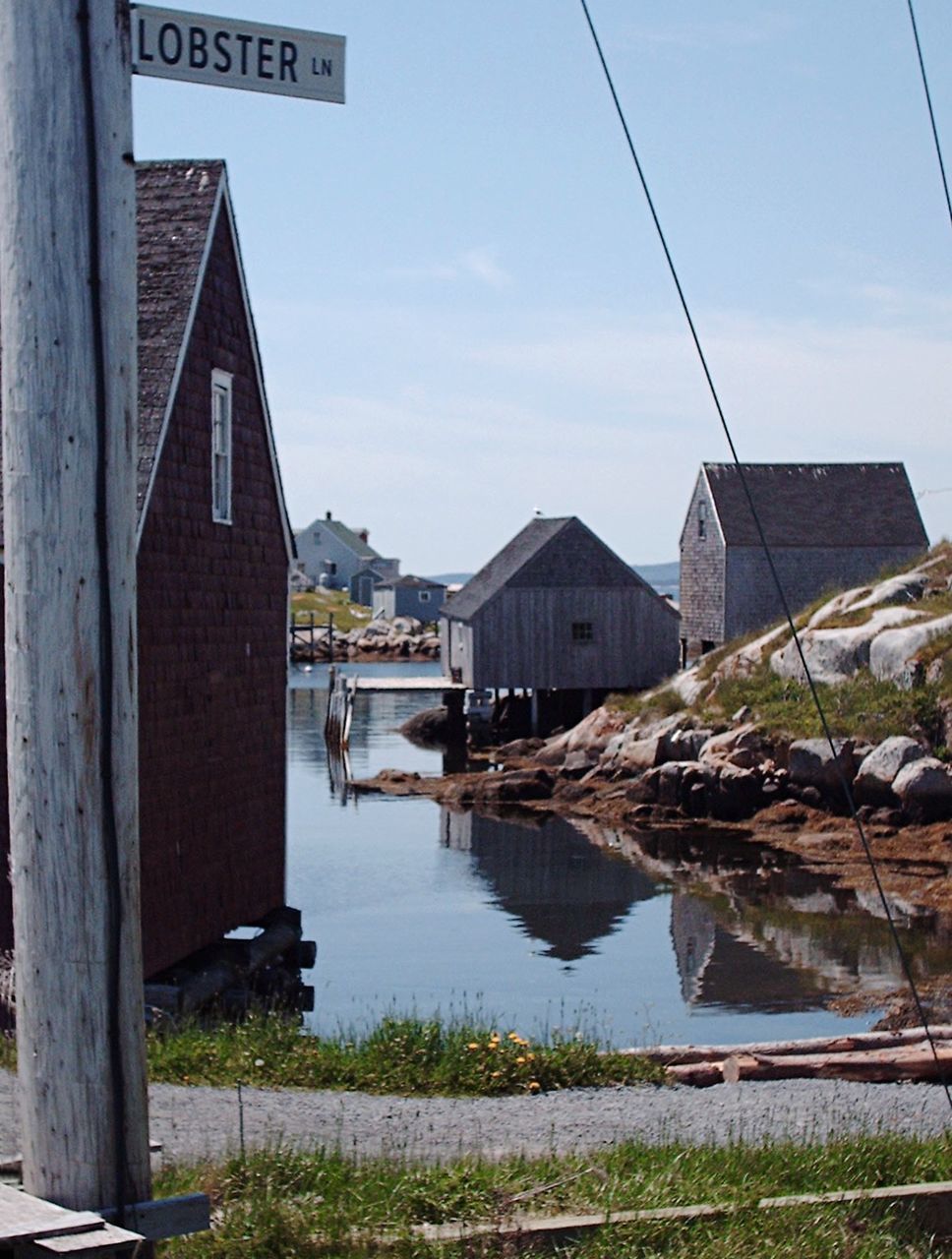 Canal amidst houses against sky at peggys cove