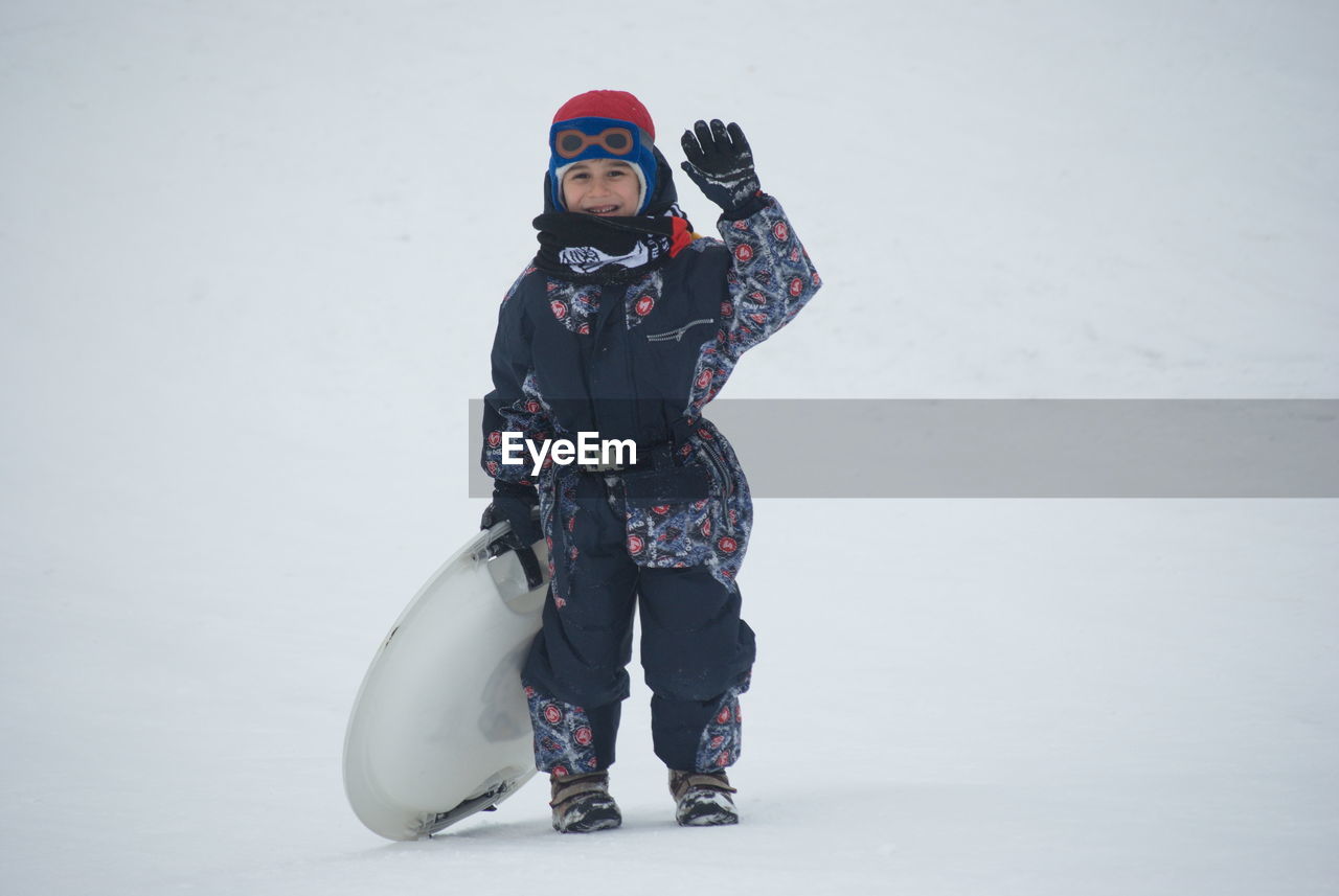 FULL LENGTH OF BOY STANDING ON SNOW FIELD