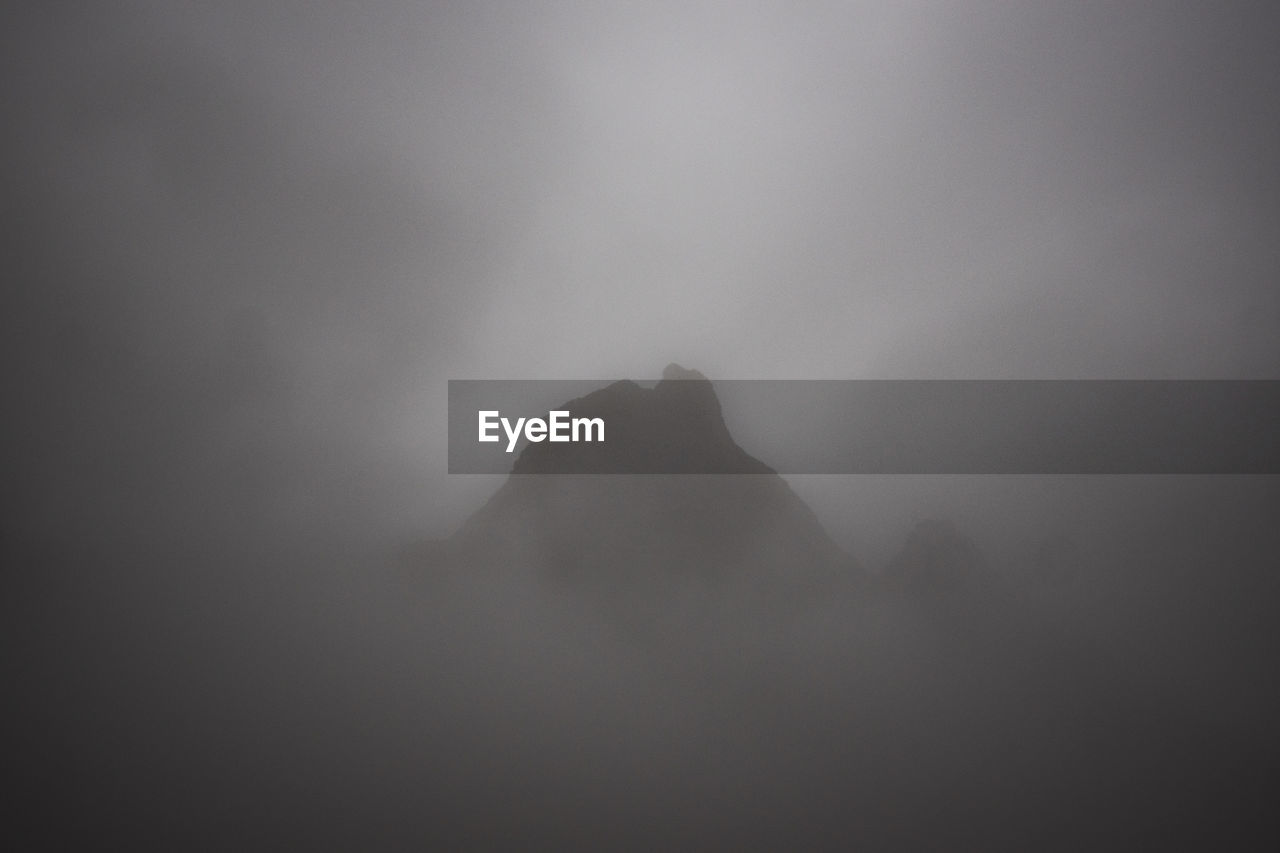 SILHOUETTE OF MOUNTAIN AGAINST SKY DURING FOGGY WEATHER
